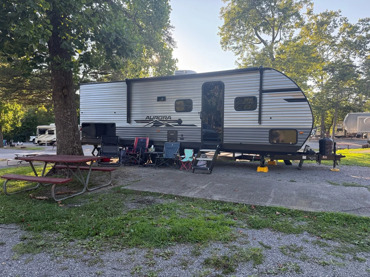 The RV Fam Adventure travel trailer set up under mature shade trees on Site 73 at Clabough's Campground