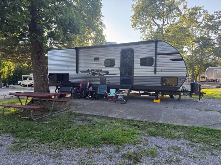 Family travel trailer set up at a wooded campground
