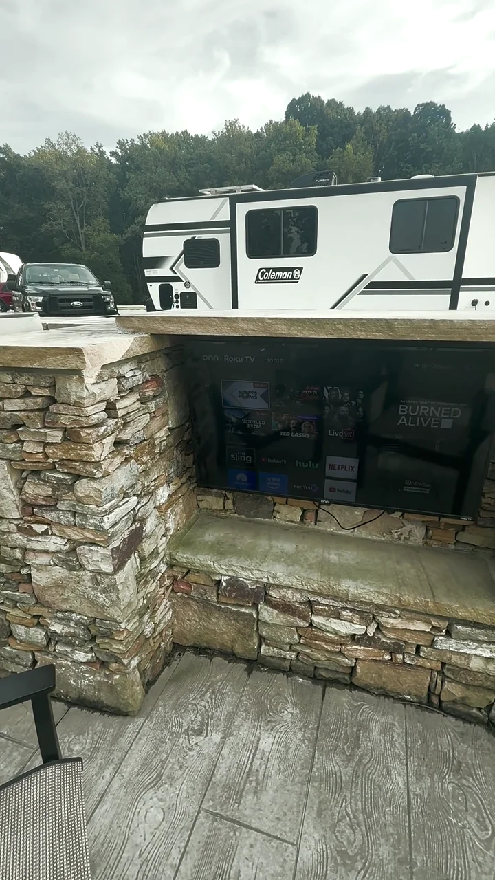 Outdoor grill, television and stone fireplace at our campsite